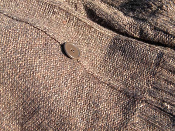 Extra button sewn into seam of sweater